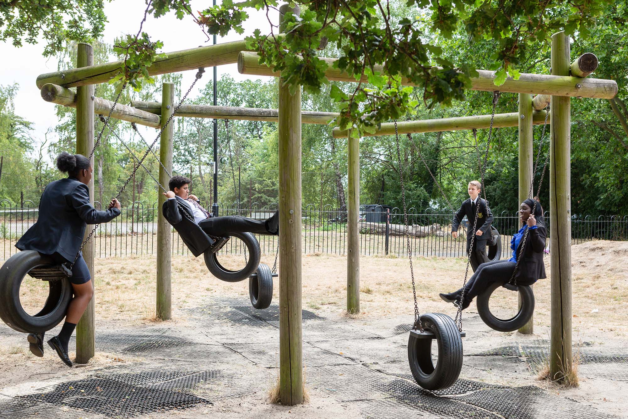 schoolchildren and adult on tyre swings