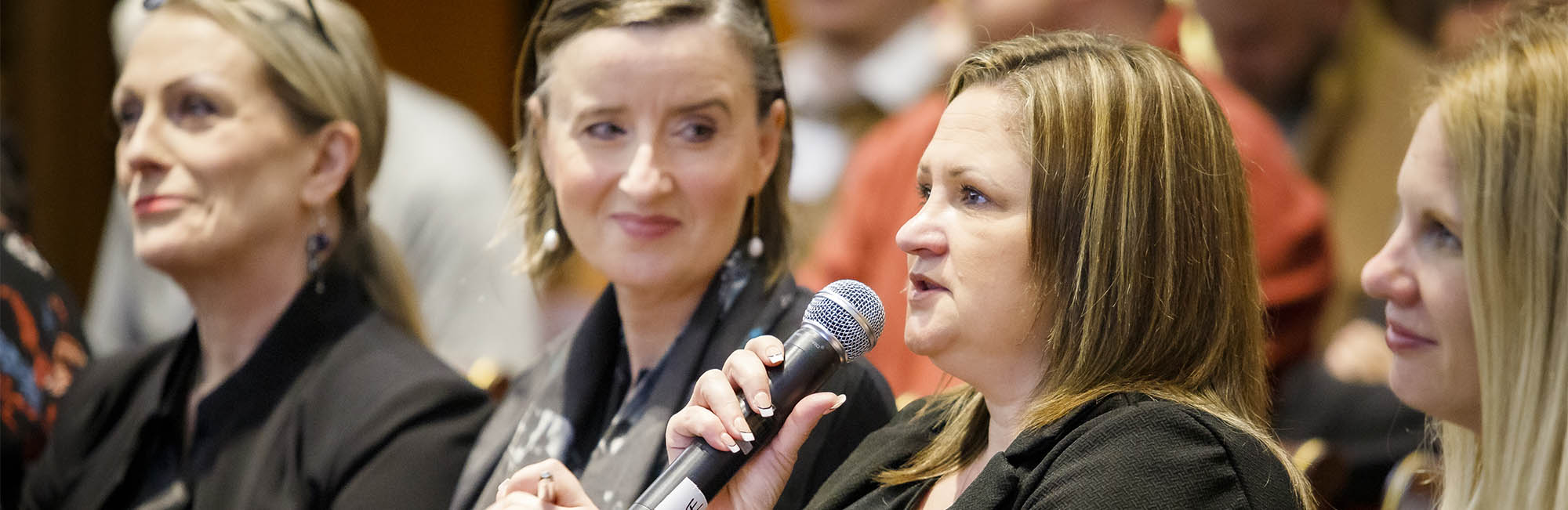 woman speaking into a microphone at an event