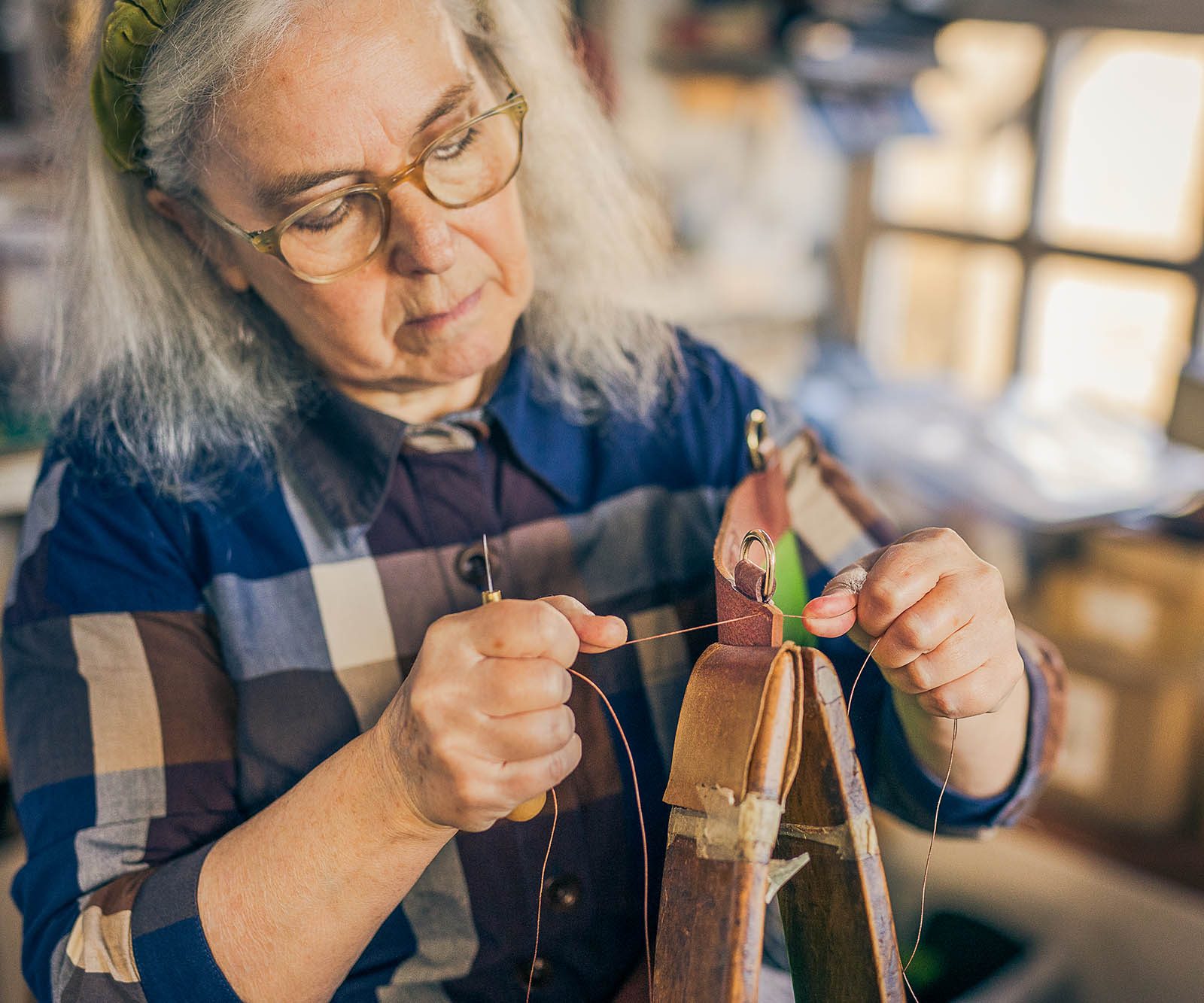 woman stitching leather