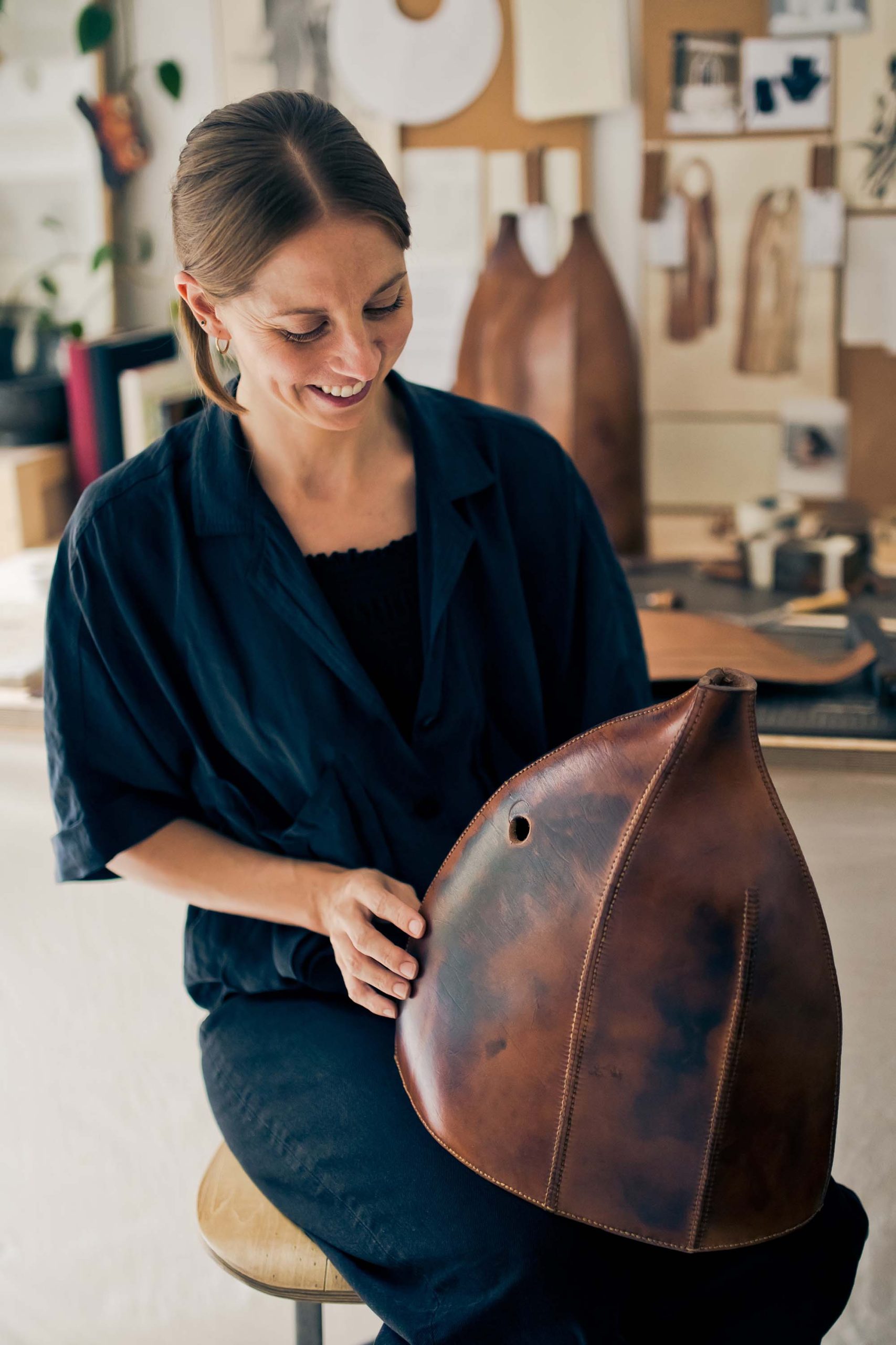 woman holding a leather sculpture