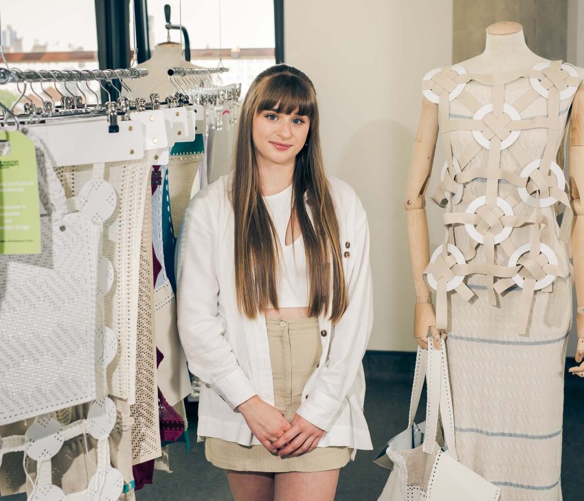 woman standing next to samples of fashion