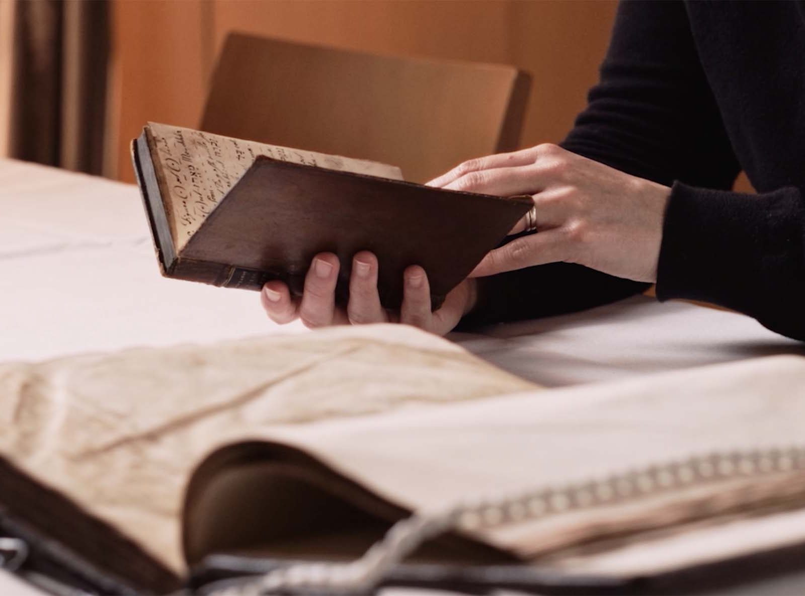 a woman looking through a leather bound book