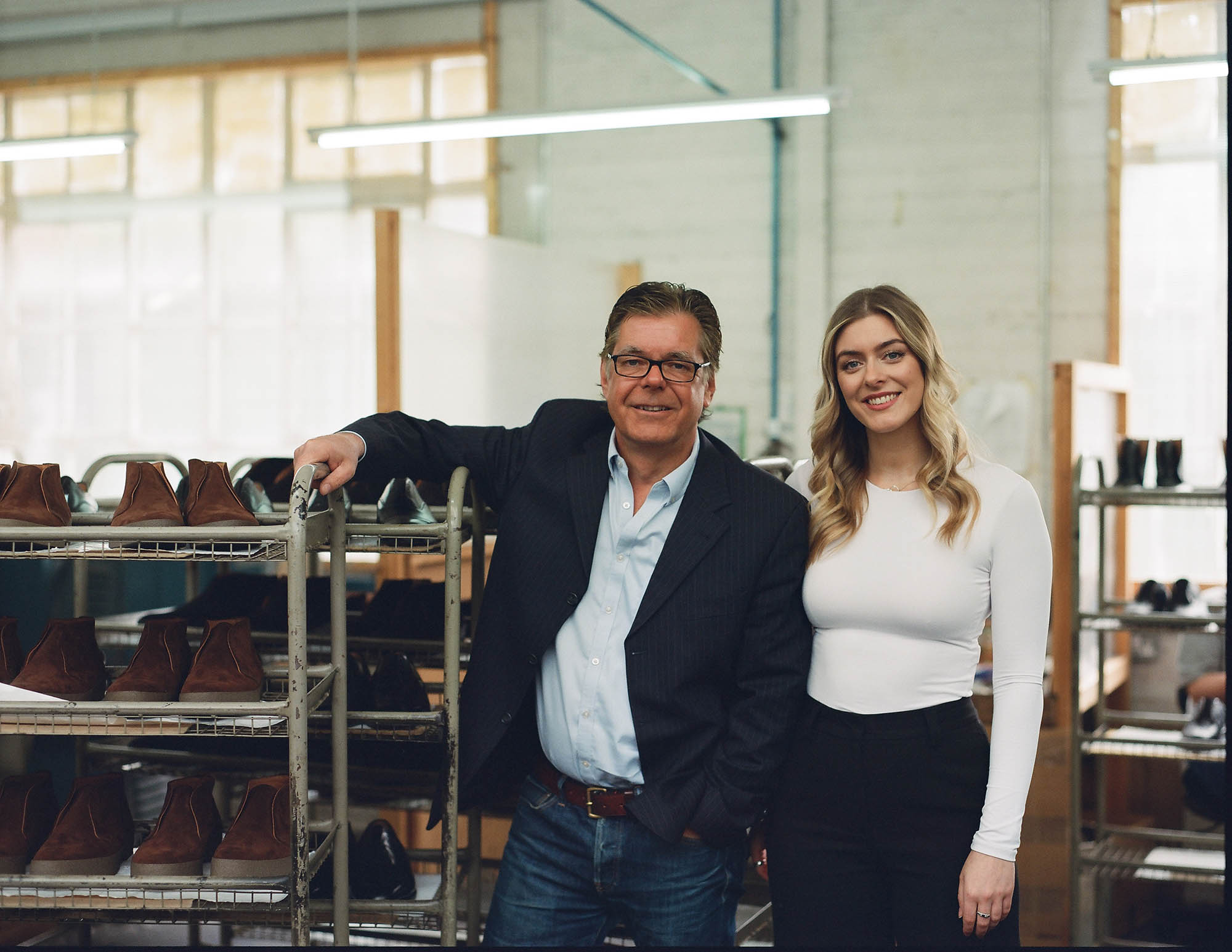 man and a woman standing in a shoe factory