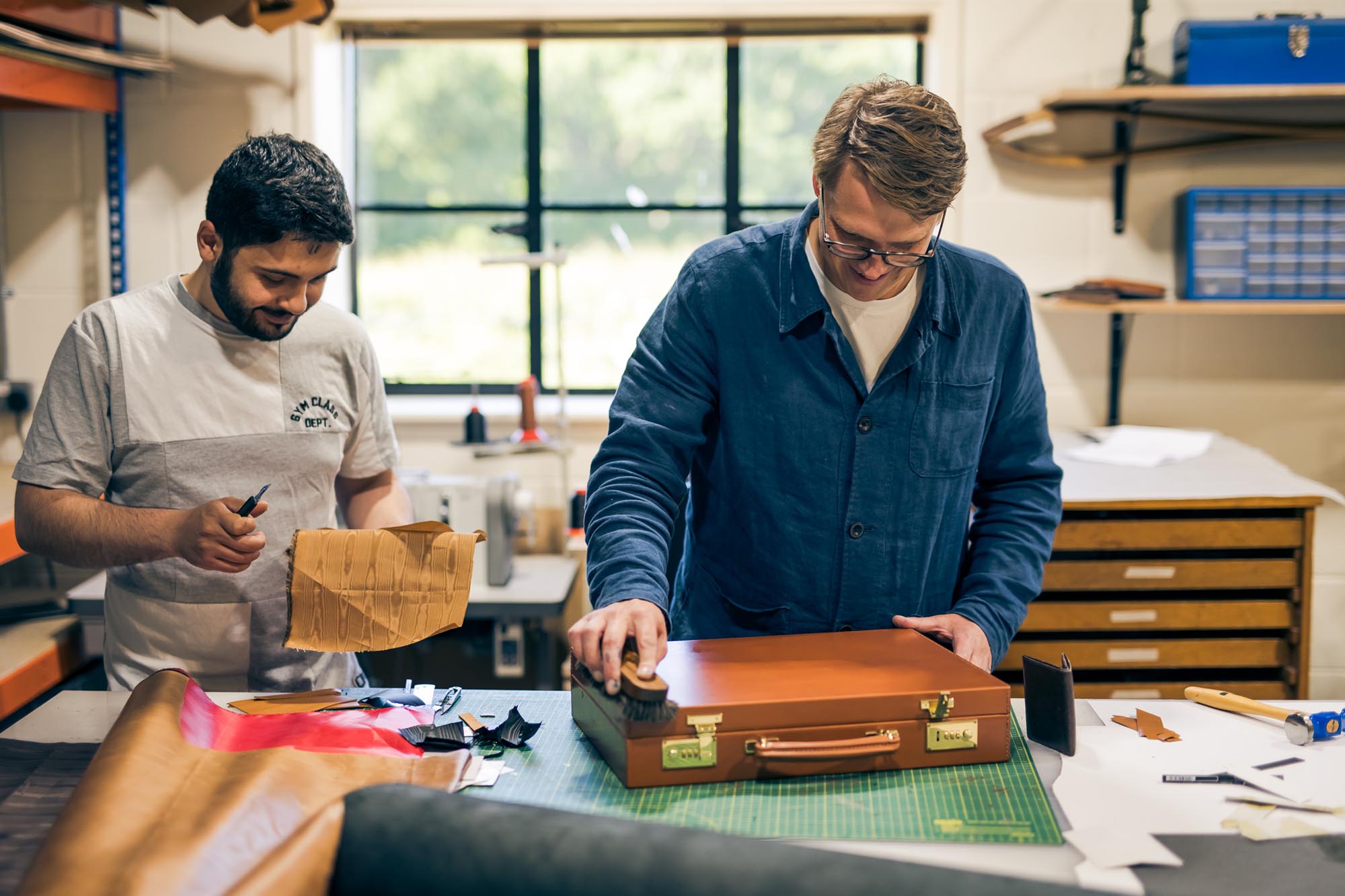 two men in a studio making leather goods