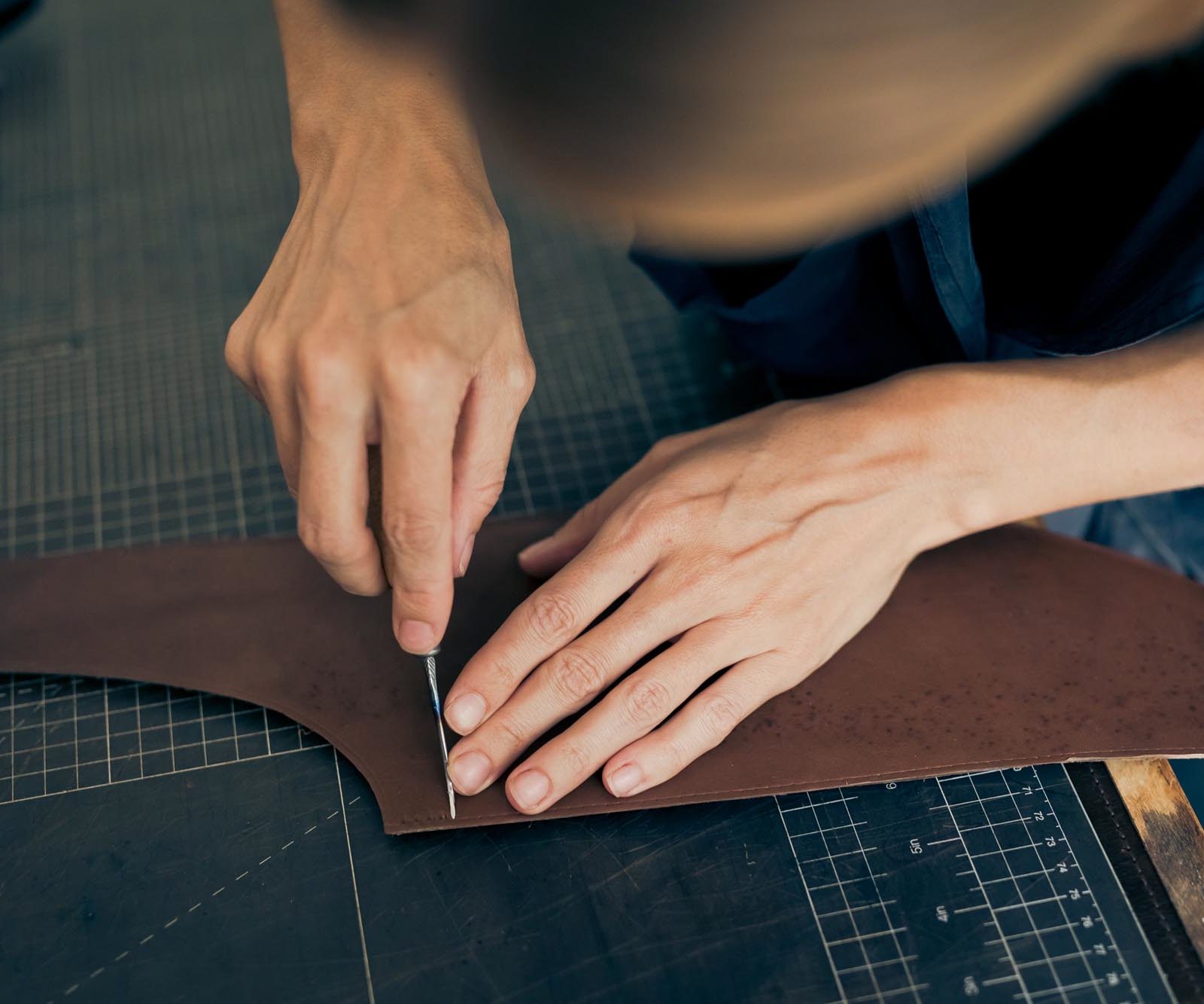 hands working on a piece of leather