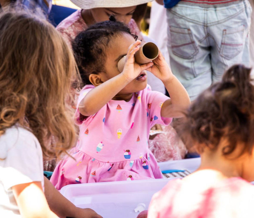 child looking through a telescope