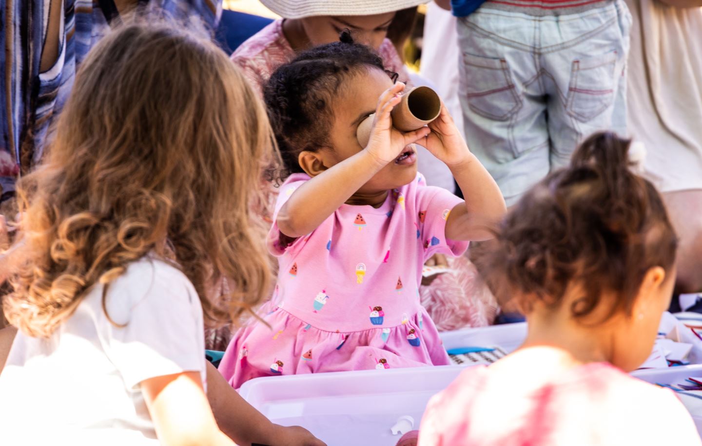 child looking through a telescope