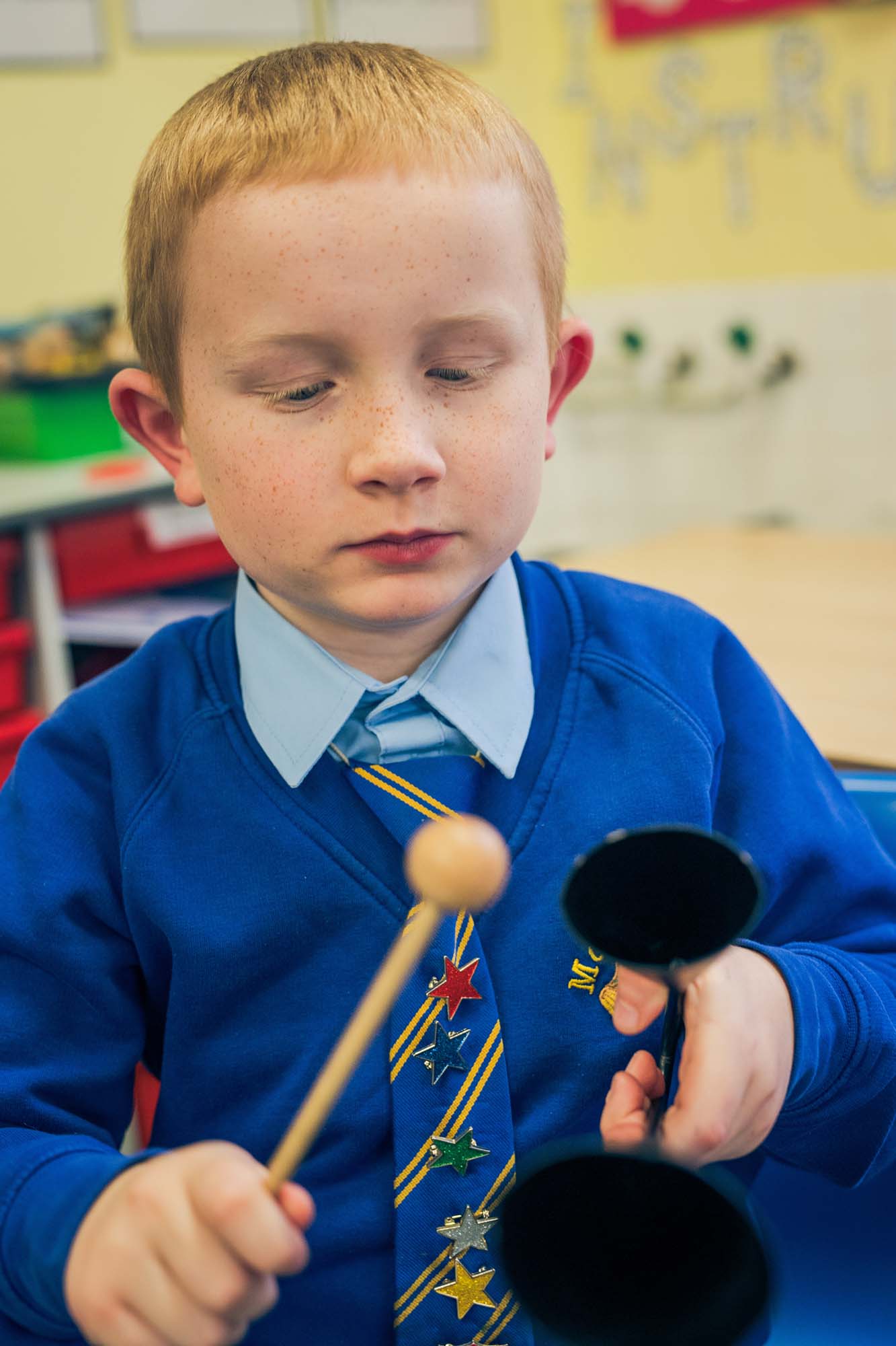 boy playing cowbell instrument