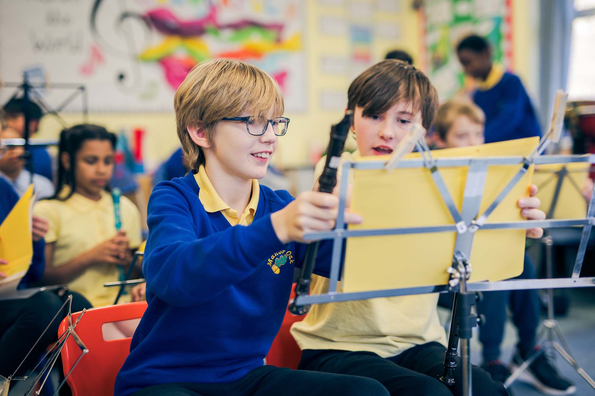 two boys with music sheets holding clarinets