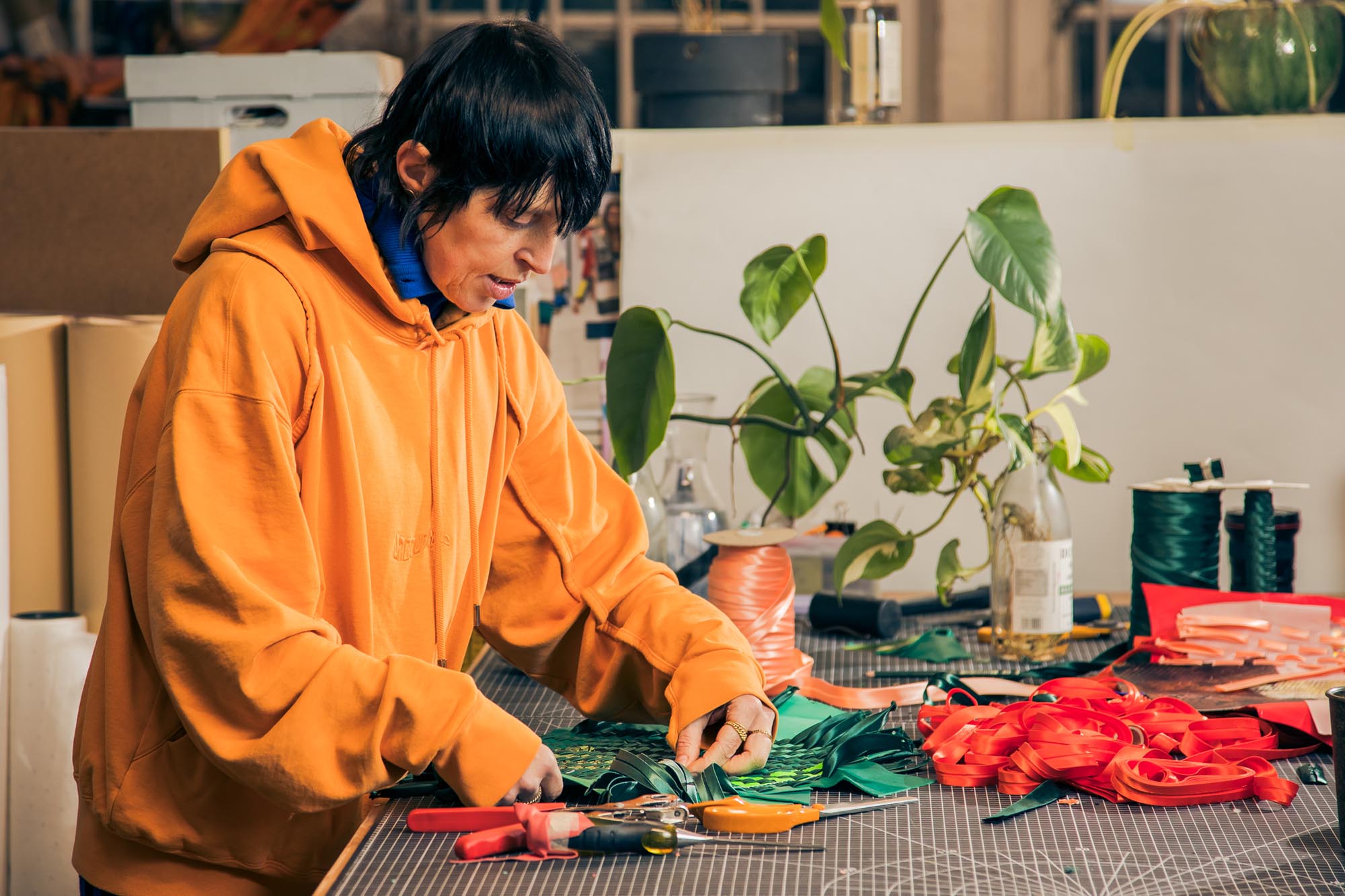 woman trimming and weaving leather strips