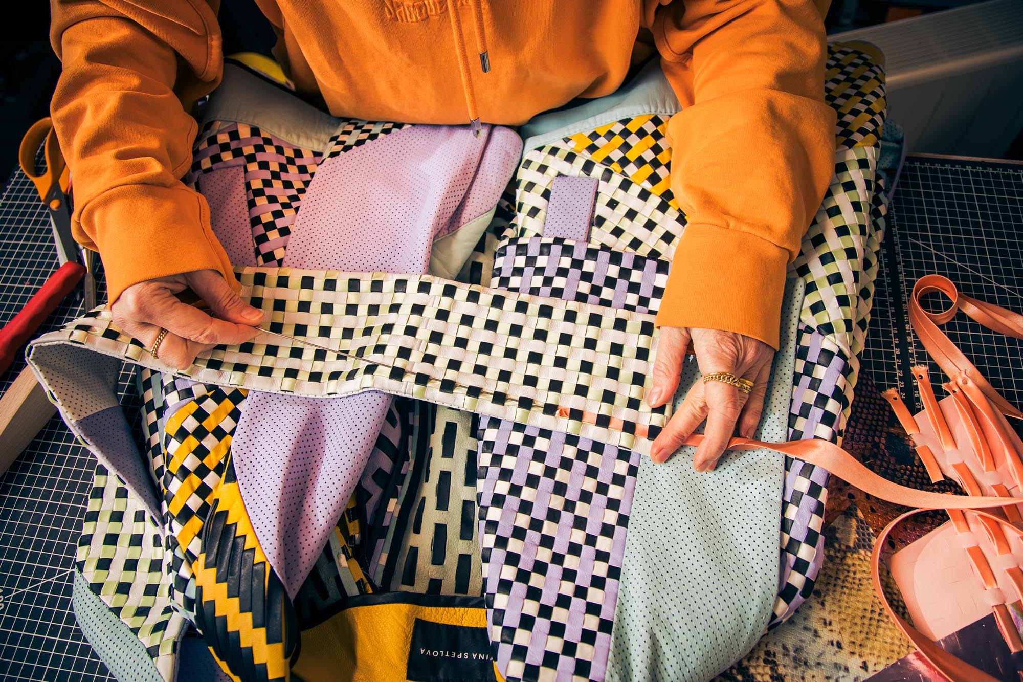 woman weaving strips of leather and fabric