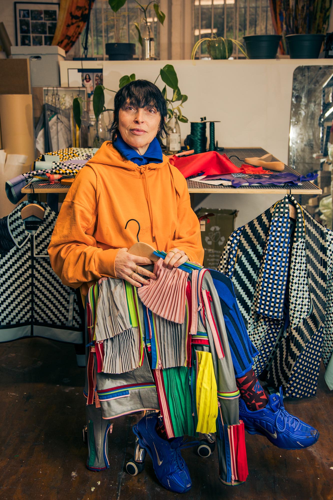 seated woman holding colourful leather jackets