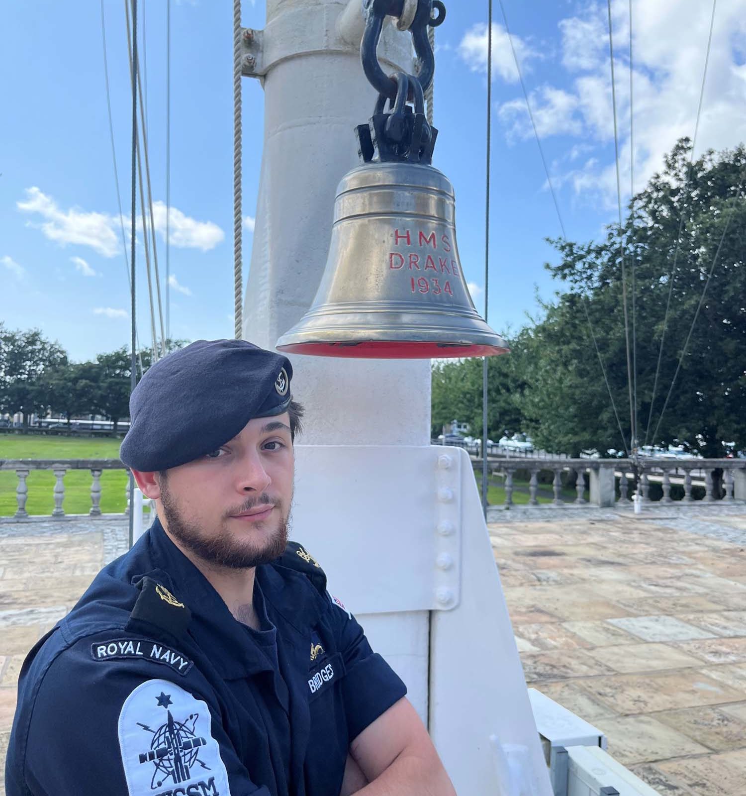 man in a blue uniform standing next to a bell