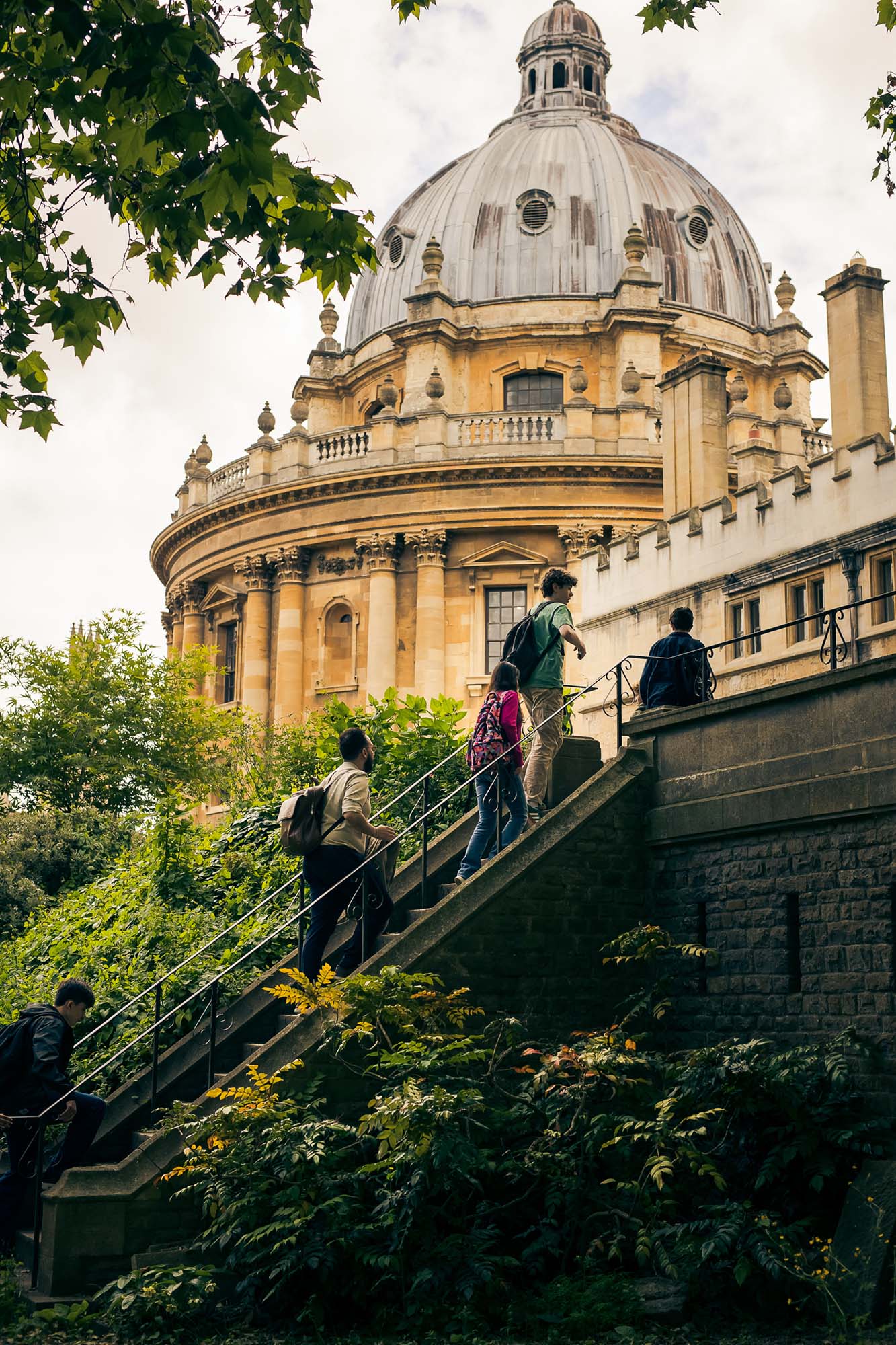 school children walking up stairs with a domed building in the background