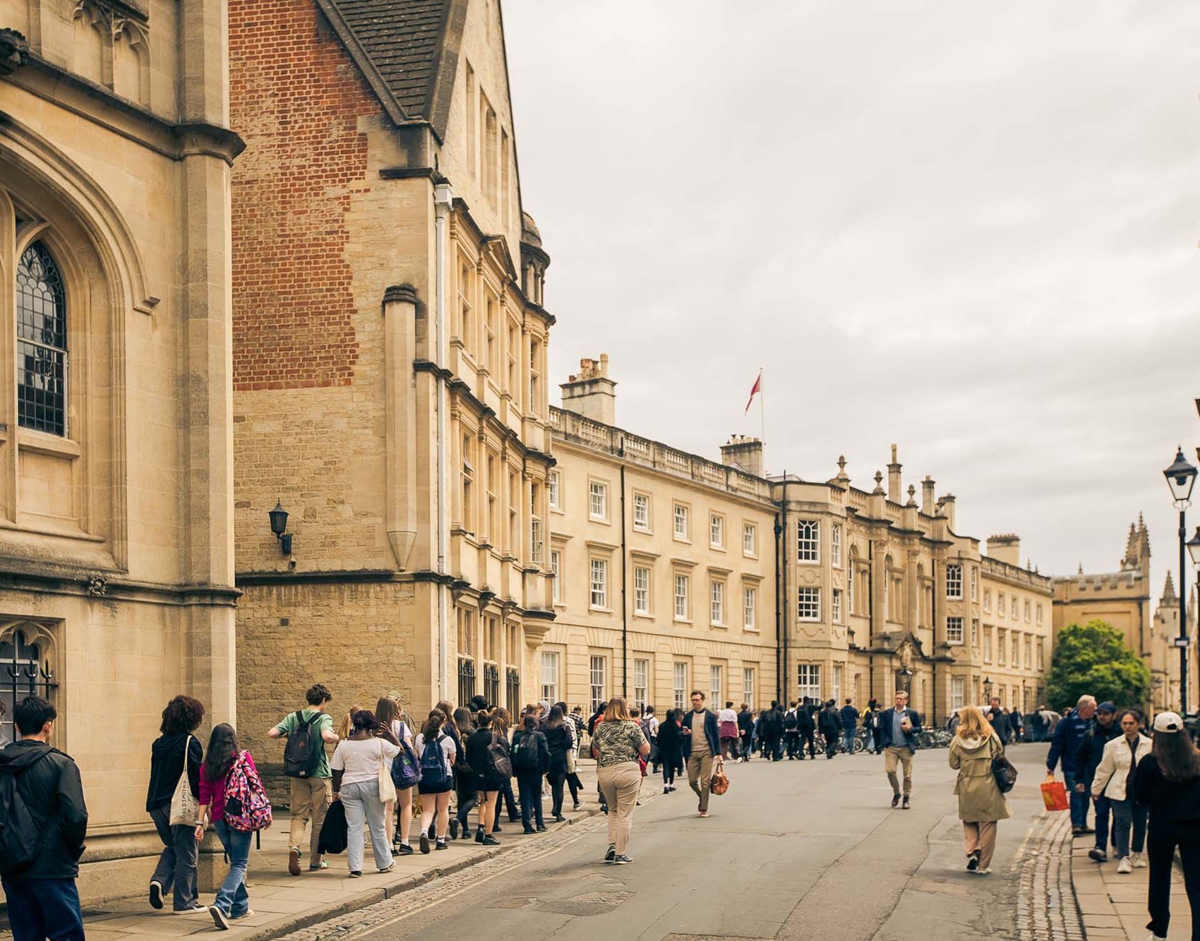 school pupils walking down a street with stone buildings