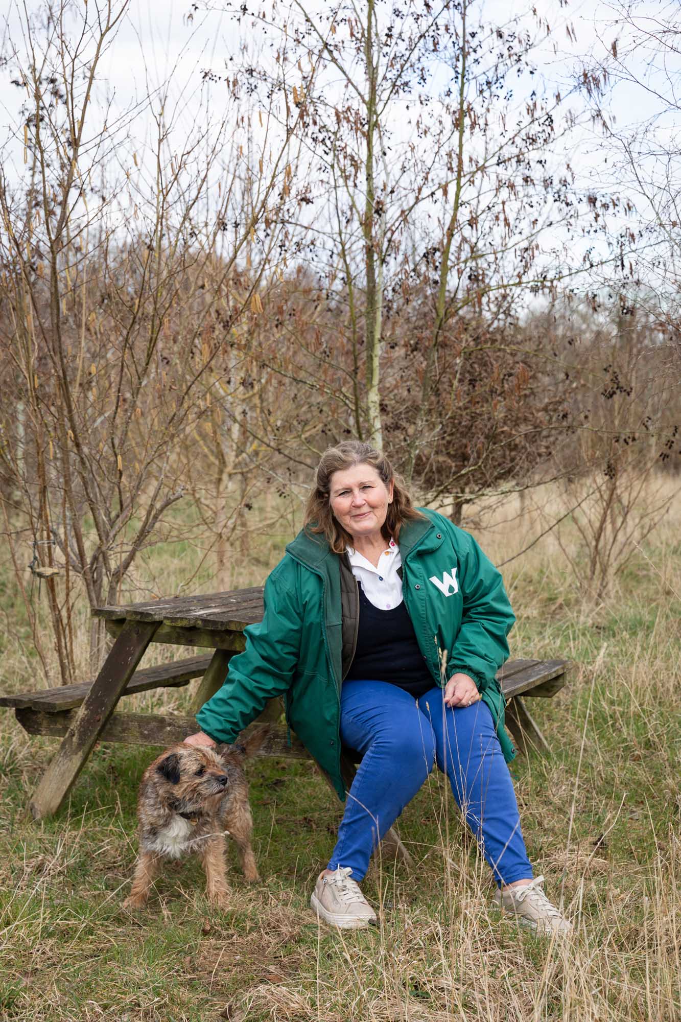 woman sitting on a bench stroking a dog