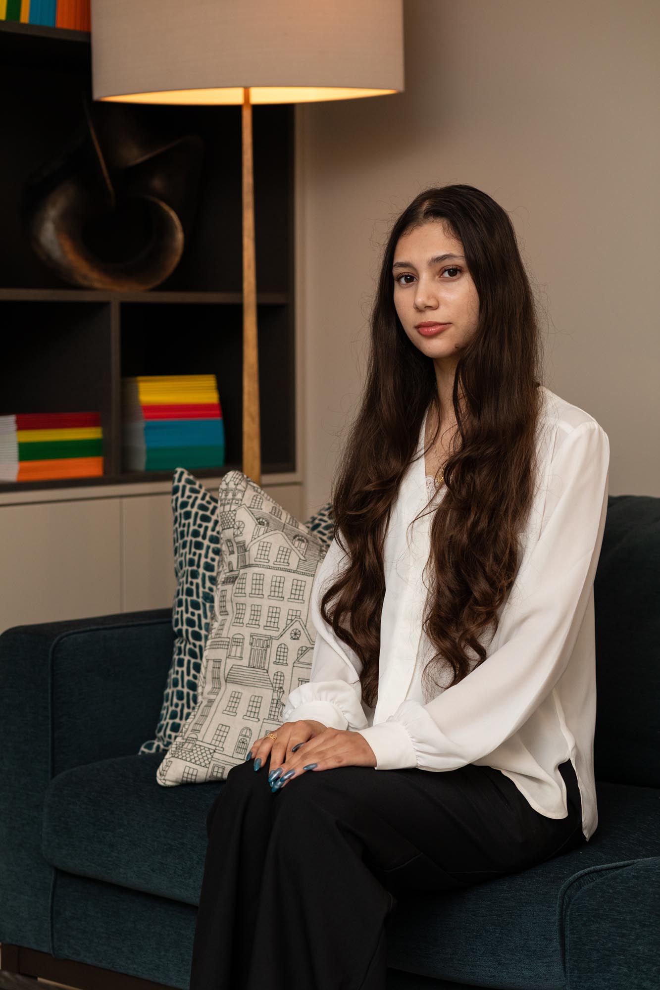 woman on a sofa with a lamp in the background